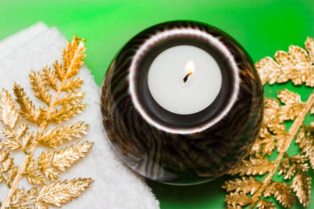 candle with towel and decorative leaves の写真素材