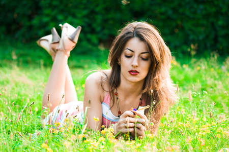 Beautiful woman lies on a grass in the field の写真素材