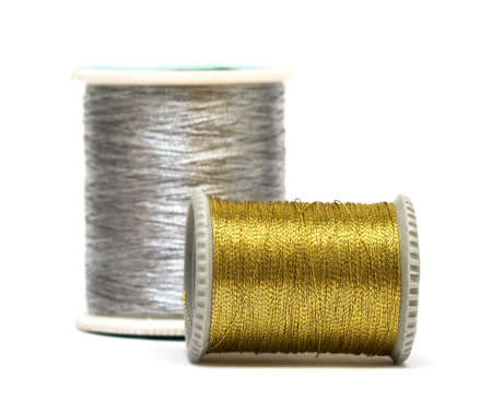 golden and silver spools of threads の写真素材