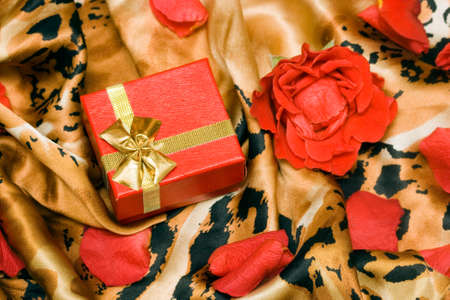 gift box with rose on a silk surface の写真素材