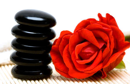 Spa essentials (pyramid of stones with white towel and rose) の写真素材