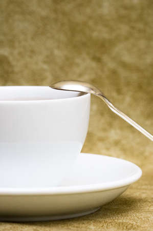White cup with saucer over brown background の写真素材