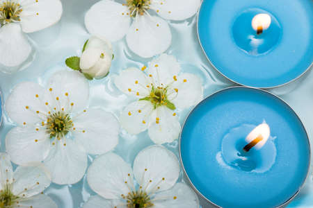 Candle with spring flowers in water の写真素材