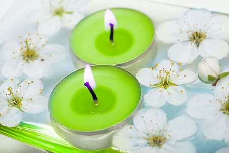 Candle with spring flowers in water の写真素材