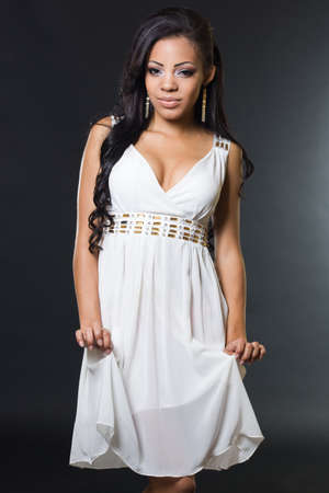 fashionable mulatto woman in white dressの写真素材