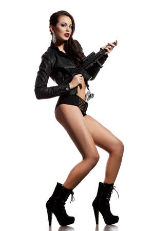 elegant fashionable woman with a gun in handsの写真素材