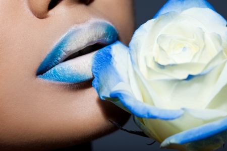 Close-up of lips with blue roseの写真素材