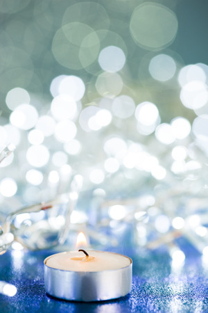 Candle with flame on sparkles backgroundの写真素材