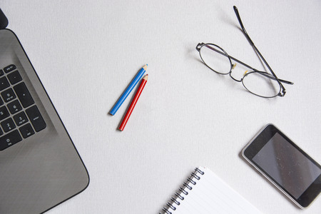 Office desk table with laptop,smart phone,pencil and notebook.Flat lay photo.Top view with copy...