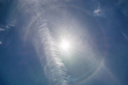 Light rings and rainbows are surrounding the sun in the sky.の写真素材