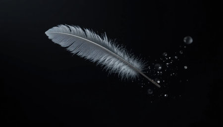 A soft feather floats gracefully in a dark setting, surrounded by shimmering particles that enhance its elegance.の素材