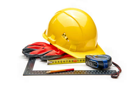 Construction tools on white background. Arrangement of hard hat, water gauge, leather gloves and measuring tape.の写真素材