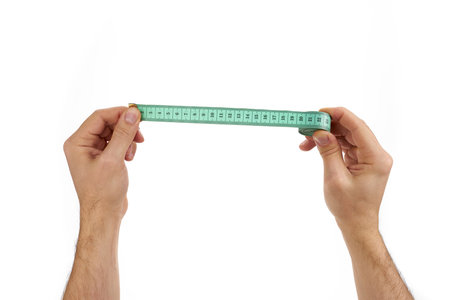 holding measuring tape in hands on a white backgroundの写真素材
