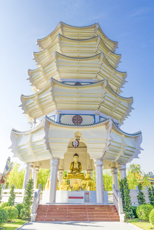 A golden Buddha statue and towers at Suphanburi Thailandの写真素材