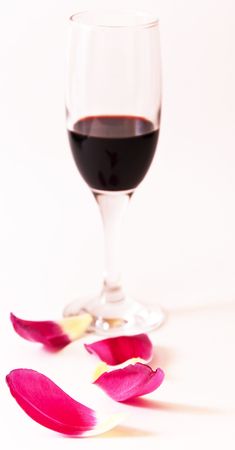 Glass of red wine with petals of spring flowerの写真素材