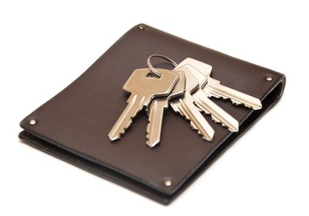 leather purse with keys from the house on white backgroundの写真素材