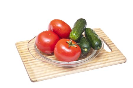 Tomatoes and cucumbers on the cutting board の写真素材