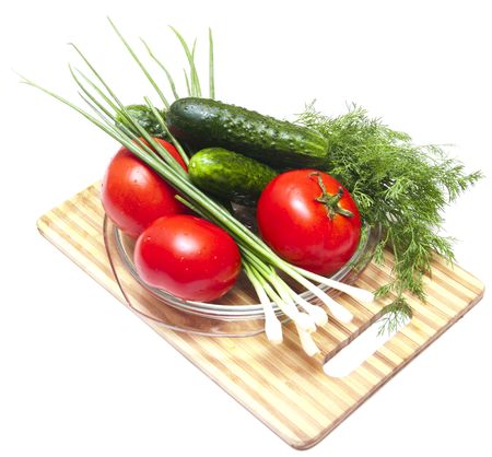 Cucumber, tomatoes and greens, close up on wooden boardの写真素材
