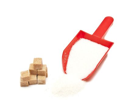 red scoop of the sugar spilling on white surface.の写真素材