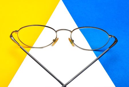 glasses for eyes on blue and yellow  backgroundの写真素材