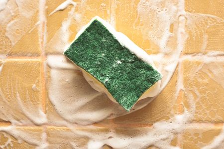 sponge for cleaning with foam on wallの写真素材