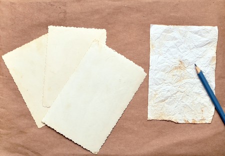 old photos, paper and pencil on brown backgroundの写真素材