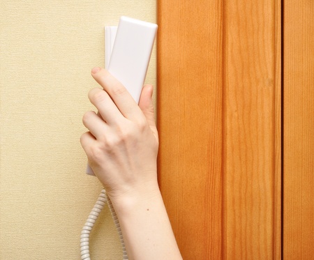 female hand holding intercom phone 