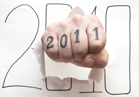 Hand punching through paper on white background の写真素材