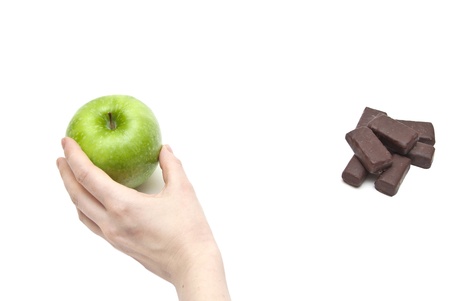 hand women choosing apple against chocolate.good nutritionの写真素材