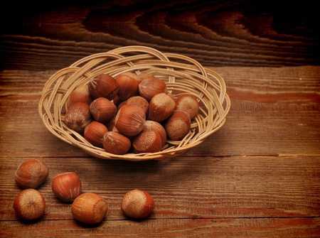 wood nuts in a basket on wood backgroundの写真素材