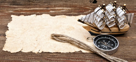 old paper, compass, rope and model classic boat on wood backgroundの写真素材