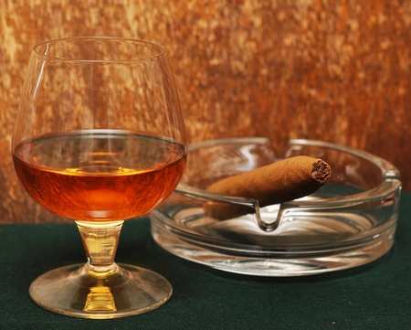 cigar and a glass of alcohol on green fabricの写真素材