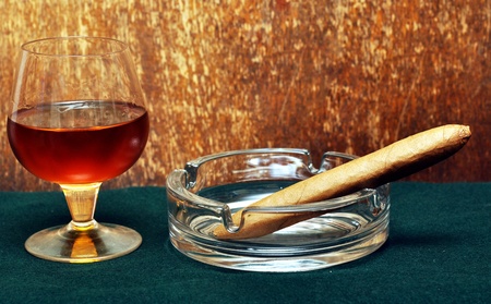Cigar on the glass with alcohol on green fabricの写真素材