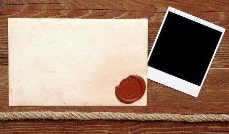 Old paper with a wax seal on a wood backgroundの写真素材