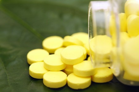 yellow pill over a green leafの写真素材