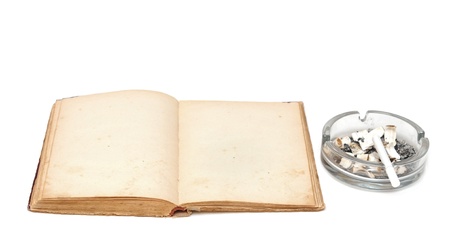 Opened old book with cigarettes in ashtrayの写真素材