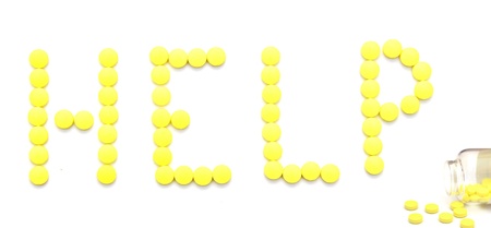 yellow pills spelling the word help over white background 