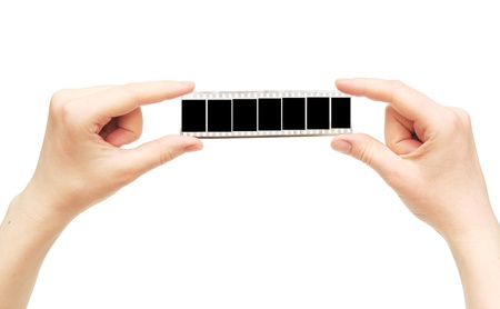 Old film with empty frame in the hands on white backgroundの写真素材