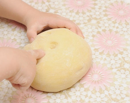Child's hands kneading dough