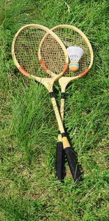 Badminton rackets on green grass 