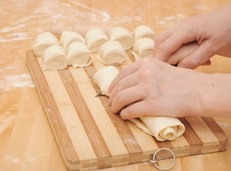 A child is helping mom cut the dough for bakingの写真素材