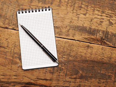 Blank note paper with pen on wood background