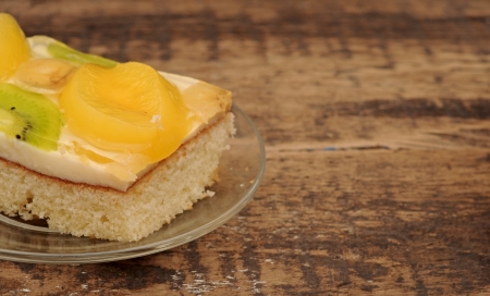 Close-up  of apricot cake on glass plate on wooden tableの写真素材