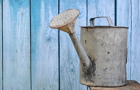 old watering can on wooden backgroundの写真素材