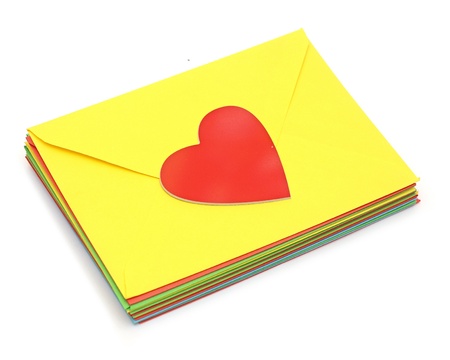 A red heart on pile colorful envelopes over white backgroundの写真素材