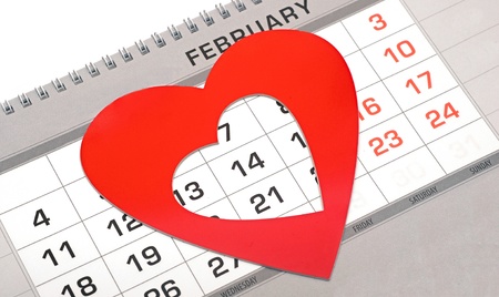 Red heart shape marker on calendar page showing February 14 Valentine's day の写真素材