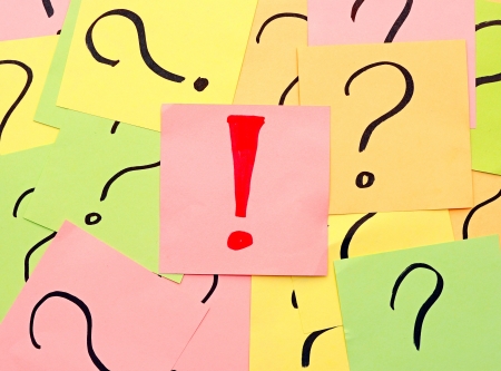 An exclamation mark among question marksの写真素材