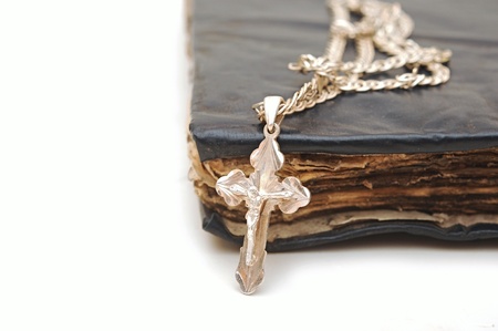 Religion  A cross with a chain against a old book