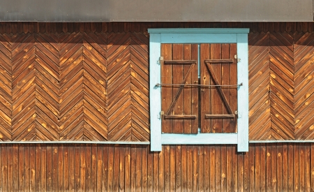 The window of the old wooden log house on the background of wooden walls の写真素材