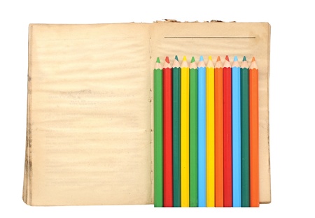 Wooden color pencils and old book on white backgroundの写真素材